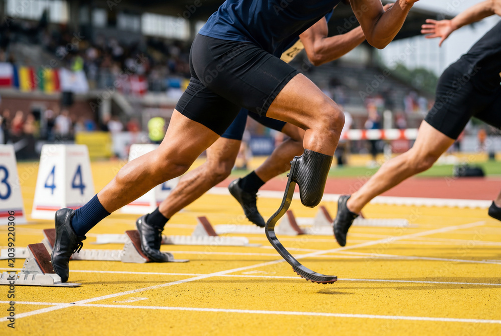 Fototapeta premium Sprinters starting race on track including athlete with prosthetic leg