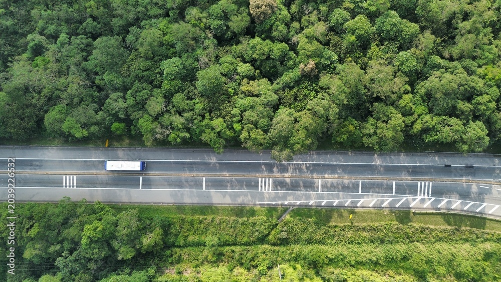 Obraz premium A rodovia Indio Tibiriça da cidade de Santo André, estado de São Paulo, Brasil, em meio à floresta tropical do bioma Mata Atlântica, em imagem aérea captada por um drone.