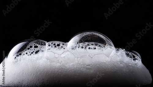 detailed view of fluffy white soap foam with small bubbles against a dark background isolated on white background
