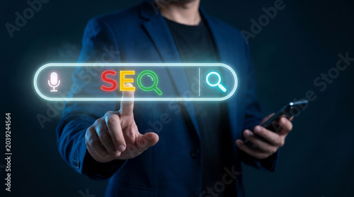 Businessman pressing glowing SEO search bar optimizing digital marketing strategy with smartphone
