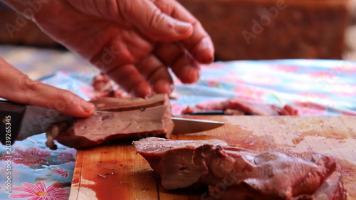 Tableau sur toile Slicing fresh lamb liver into pieces for Moroccan boulfaf skewers