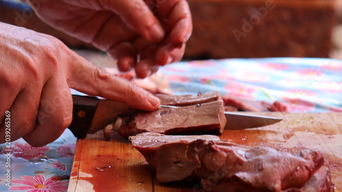 Bild auf Leinwand Slicing fresh lamb liver into pieces for Moroccan boulfaf skewers