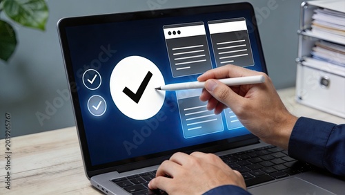 Hand holding stylus pen checking documents and checklist on laptop display screen, approval verification process concept, digital signature authorization, business administration