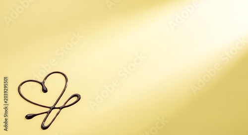 Chocolate heart drizzle on elegant gold background, dark cocoa syrup heart shape on golden surface, romantic dessert decoration for luxury food branding