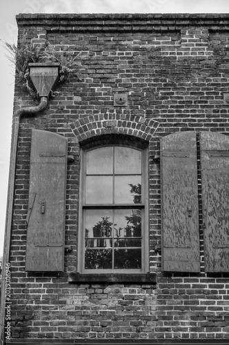 Foto Old Brick Building with an Arched Window Reflecting the Sky.