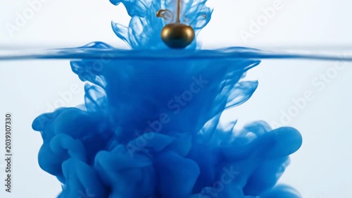 single blue water drop falling into calm water surface