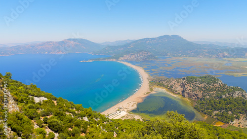 Dalyan, Turkey. Aerial drone panorama of Iztuzu Turtle Beach with golden sand spit between Dalyan River and Mediterranean Sea, forest covered mountains.. Aerial View