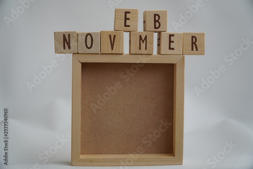 Wooden Blocks Spelling November Month Above Empty Wooden Frame With White Background