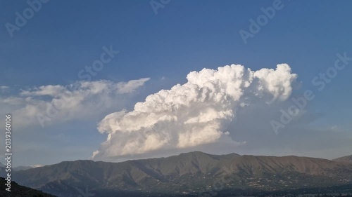 Hyperlapse or timelapse of Moving white Clouds Across a Bright Blue Sky Background