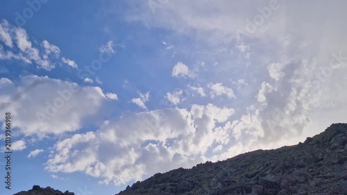 Hyperlapse or timelapse of Moving white Clouds Across a Bright Blue Sky Background
