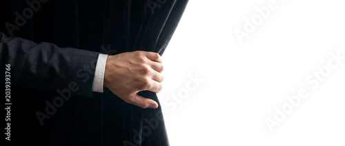 Man in Suit Pulling Open a Black Curtain Revealing a Bright White Space