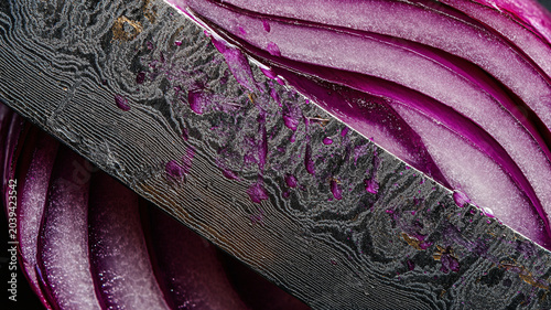 Damascus knife slicing fresh red onion macro