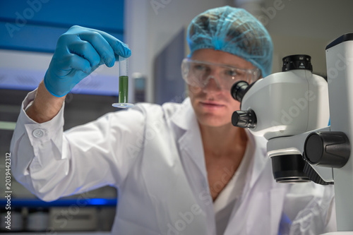 Fotografie Focused male scientist wearing lab coat intently conducting research on epidemic