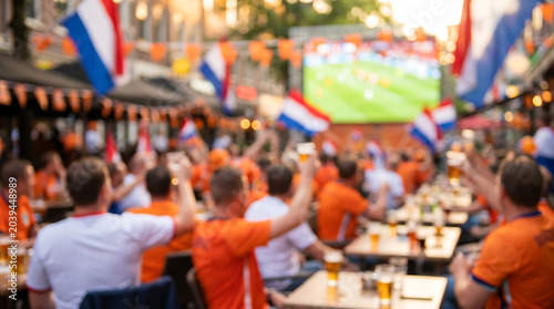 Intentionally blurred Netherlands soccer fans in orange jerseys cheering at a football match viewing party for sports media backgrounds and event marketing