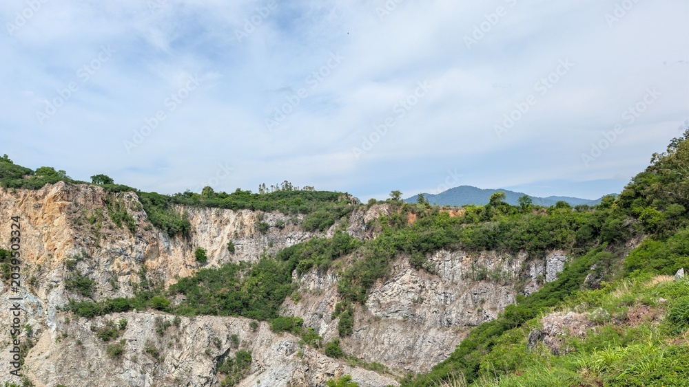 Fototapeta premium An old canyon where crushed stone production has ceased. The canyon is overgrown with plants.