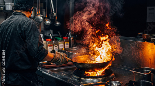 Fotografía Professional chef stir-frying in a large wok over intense flames, creating a dynamic and delicious meal