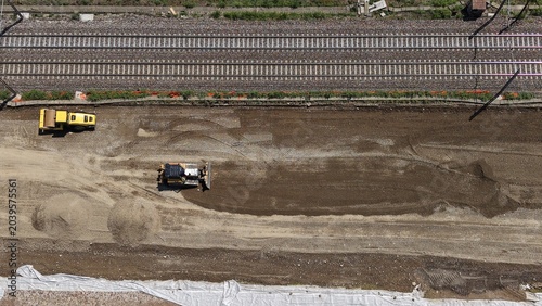 Construction Site Aerial View: An overhead drone shot captures a bustling construction site with heavy machinery, including a bulldozer and a grader.
