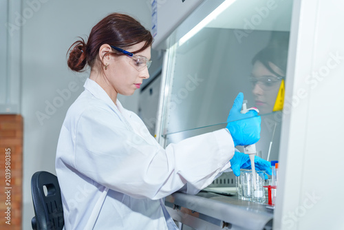 Foto Scientist in protective gear meticulously works with a pipette inside a sterile