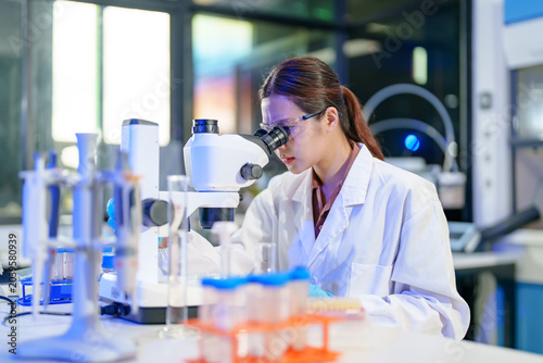 Scientist examining sample under microscope in modern laboratory setting