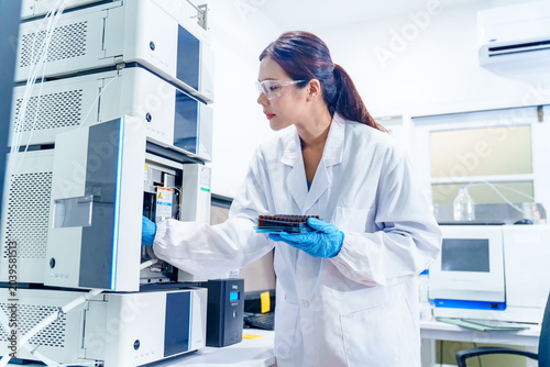 Schilderij op canvas Scientist in lab coat and gloves working with advanced chromatography equipment