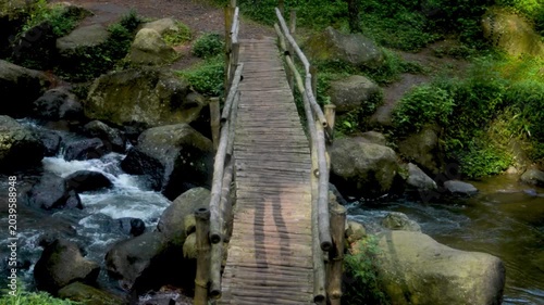 Wooden bridge over stream in Java mountain landscape