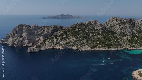 vue aérienne de la calanque de Sormiou au sud de Marseille, en été, avec des bateaux dans la baie et l'archipel du riou en arrière plan