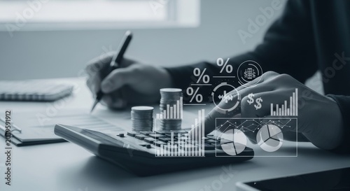 Accountant calculating financial growth with coins and calculator while reviewing paper documents and digital economy charts overlay in office workspace environment
