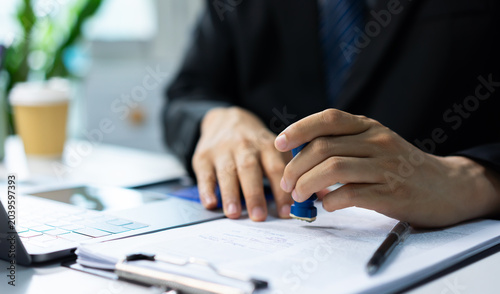 Photos Businessman signs documents at a polished desk