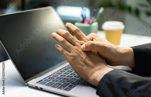 Quadro su tela Businessman experiences pain on the back of his hand when pressing it with his fingers this relates to concepts of arthritis, trigger finger and hand health diagnosis