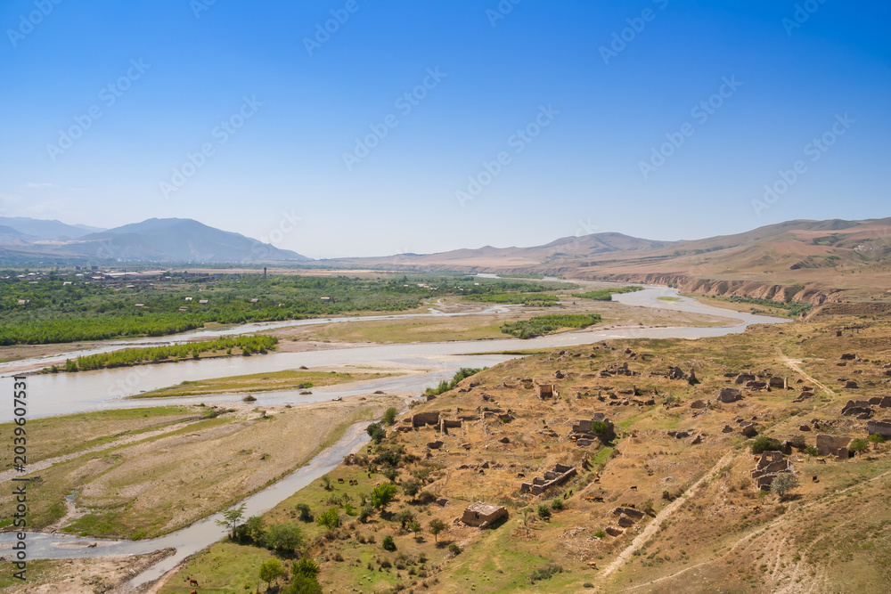 Fototapeta premium Mtkvari River cuts through the valley near Uplistsikhe ruins of Gori
