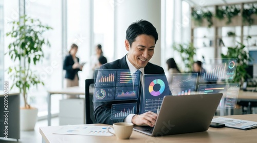 Business executive managing financial data visualization on modern laptop computer with holographic charts and graphs floating in professional office workspace area