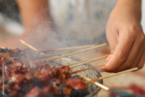 Indonesian sate ayam barbecue cooking process close-up view