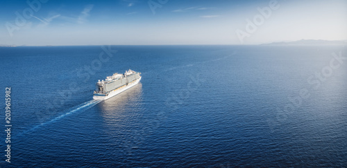 Photos Panoramic aerial view of a cruisehip sailing into the sunset over calm ocean wit
