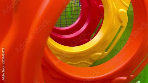 Vibrant close-up of colorful plastic rings in orange, red, and yellow, forming an abstract pattern, likely part of a children's playground.
