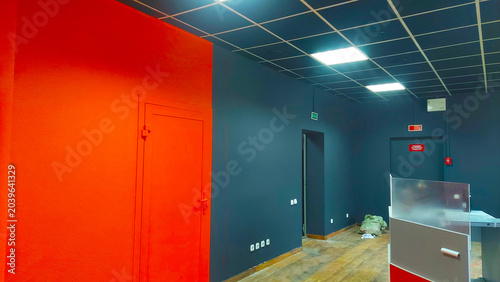 Obraz na płótnie Work is in progress in a room with orange and gray walls and new lighting setup
