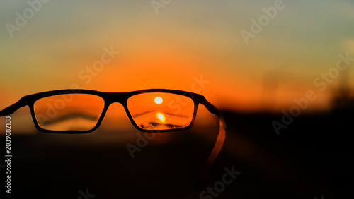 Vision Concept with Eyeglasses and Sunset Background