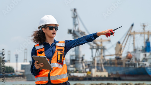 Foto Woman wears a white hard hat and orange safety vest