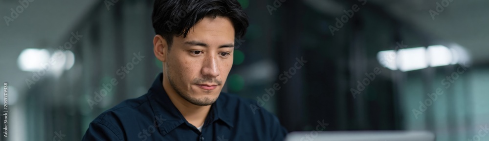 Obraz premium Man using laptop in office server room environment