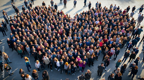 Diverse group of people forming a heart shape together outdoors