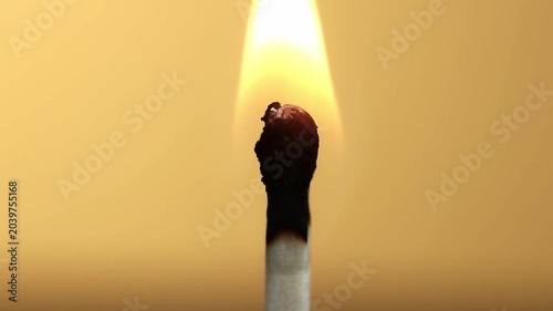burning candle on a yellow background