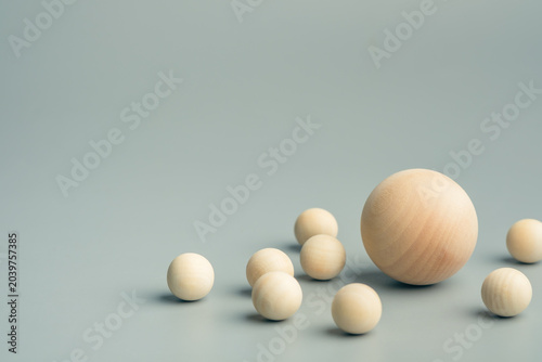 Foto Wooden spheres of different sizes arranged together with one larger sphere at ce