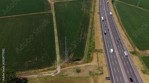 Aerial View of Highway A50 and Farmland: An expansive drone shot captures a bustling highway cutting through vast agricultural fields. Italy, Milan