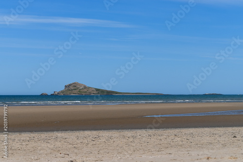 Photos Scenic view of Irelands Eye island and Martello tower from the sandy beach of Po