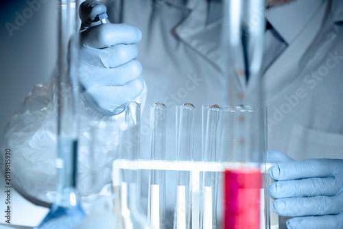 Canvas Print Gloved hands handling pharmaceutical samples results in lab, drug testing and quality control with chemical glassware and solutions