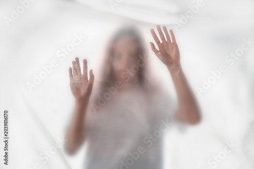 Foto Woman pressing her hands against transparent plastic, symbolizing eco anxiety, climate change fear, plastic pollution and mental health crisis connected to environmental stress