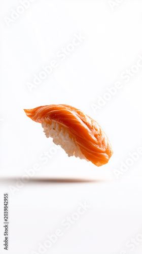 A delicious salmon sushi nigiri hovering over a white surface, ready to be enjoyed