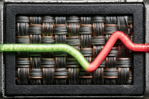 Network security traffic graph with glowing green line and red warning line woven over dark metal texture, dramatic studio lighting and copy space
