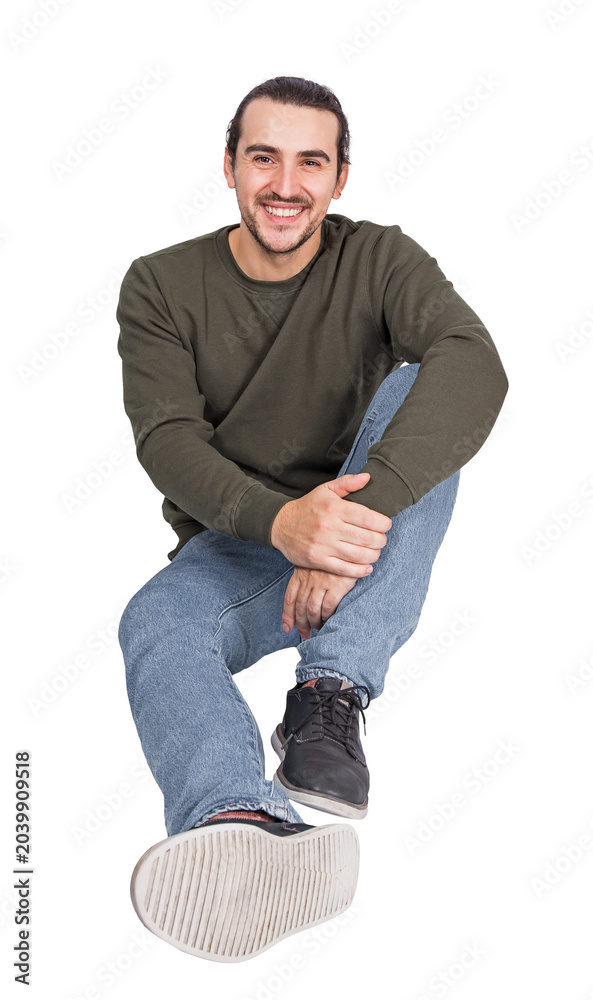 Fototapeta premium Joyful young man sitting relaxed on the floor, smiling to camera. Lifestyle full length portrait happy guy isolated on transparent background with copy space