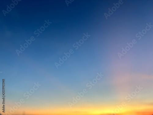 Defocused sunset sky gradient background. Abstract smooth blur of deep blue and vibrant orange colors with ample copy space for design templates.