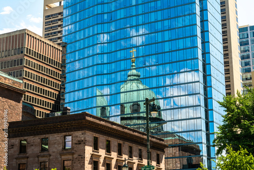 Reflection of the Cathedral Basilica dome in a modern glass facade in Philadelphia, Pennsylvania, showing contrast of historic and contemporary architecture.